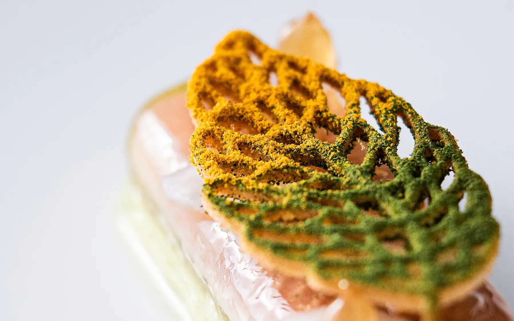 Filigranes Dessert mit orange-grüner Tuile als Sinnbild für ein besonderes Geschenk